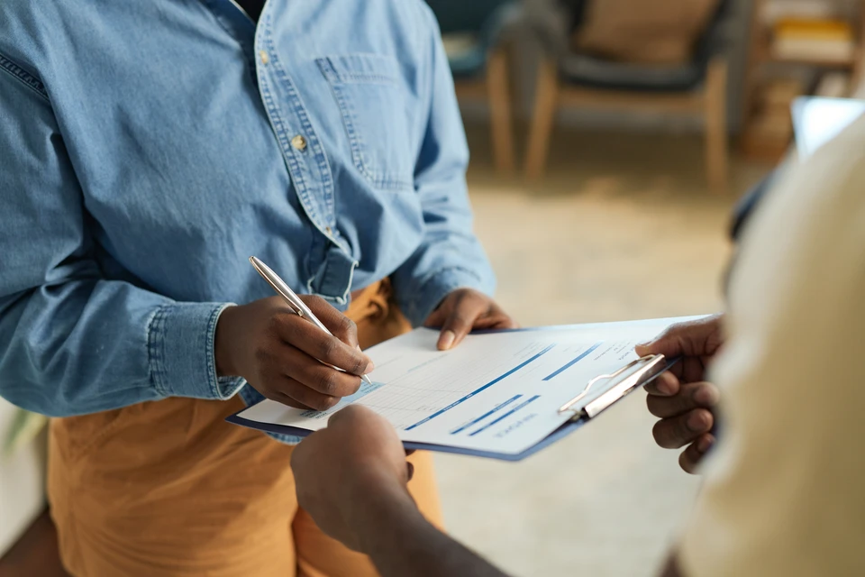 Technicien en combinaison de travail effectuant une inspection sous un équipement de chauffage ou climatisation